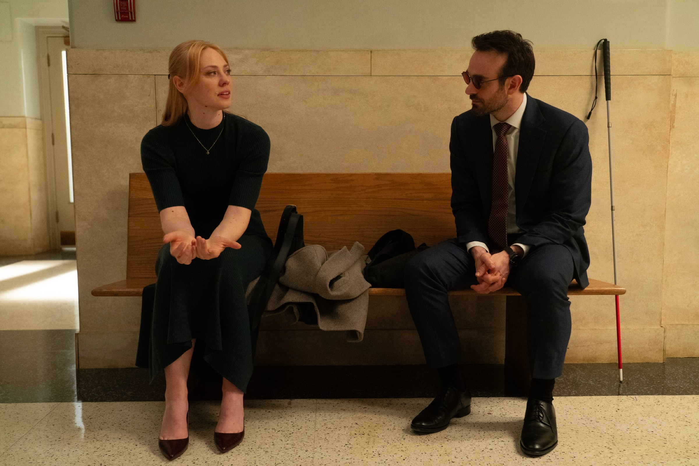 Karen and Matt sitting on opposite side of a bench. From Daredevil: Born Again